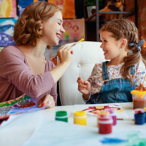 mother and child daughter painting draws are engaged in creativity in kindergarten